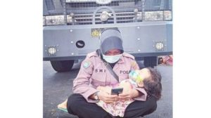 Bertugas Sambil Mengasuh Anaknya, Foto Polwan Ini Viral di Media Sosial
